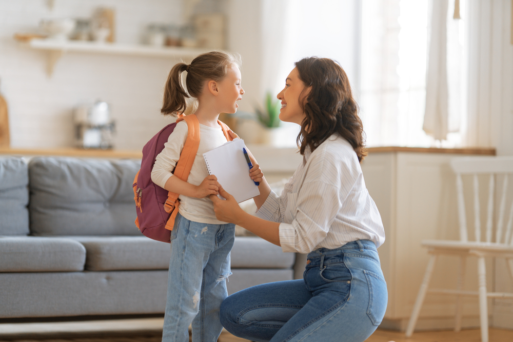 Happy family preparing for school. Little girl with mother.